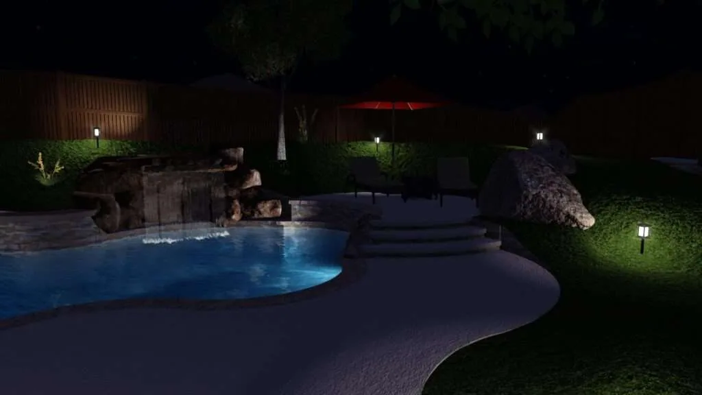Nighttime backyard pool area with illuminated blue water, stone waterfall feature, curved deck, landscape lighting, and manicured lawn